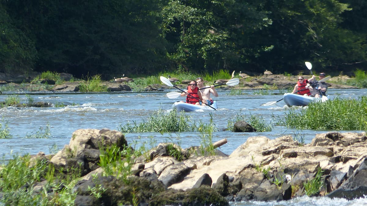 Kayakers paddling through mild rapids near Lillington, NC