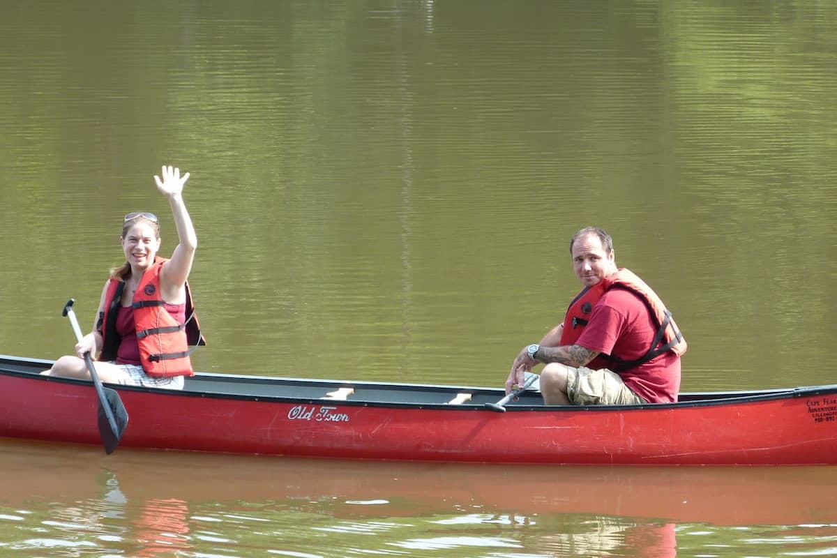 Couple in a canoe waiving near Lillington, NC