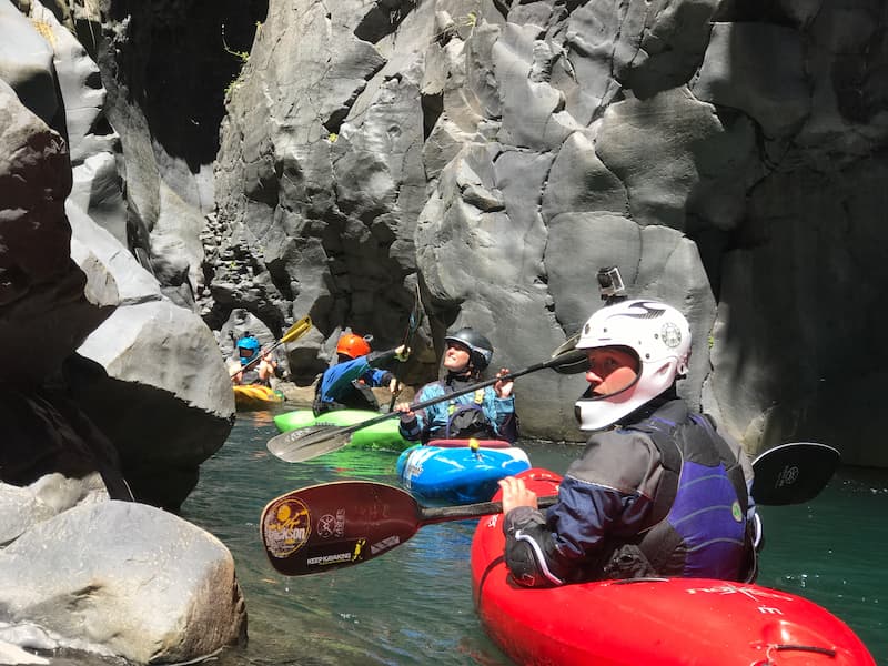 Group of kayakers paddling with volcano in the backgroun in Pucón, Chile