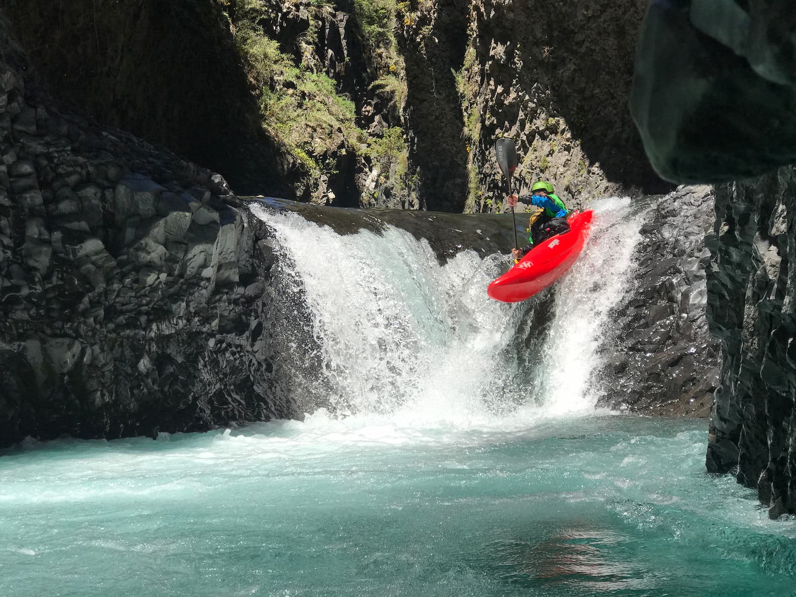 Whitewater kayaker paddling down a small waterfall in Pucon, Chile