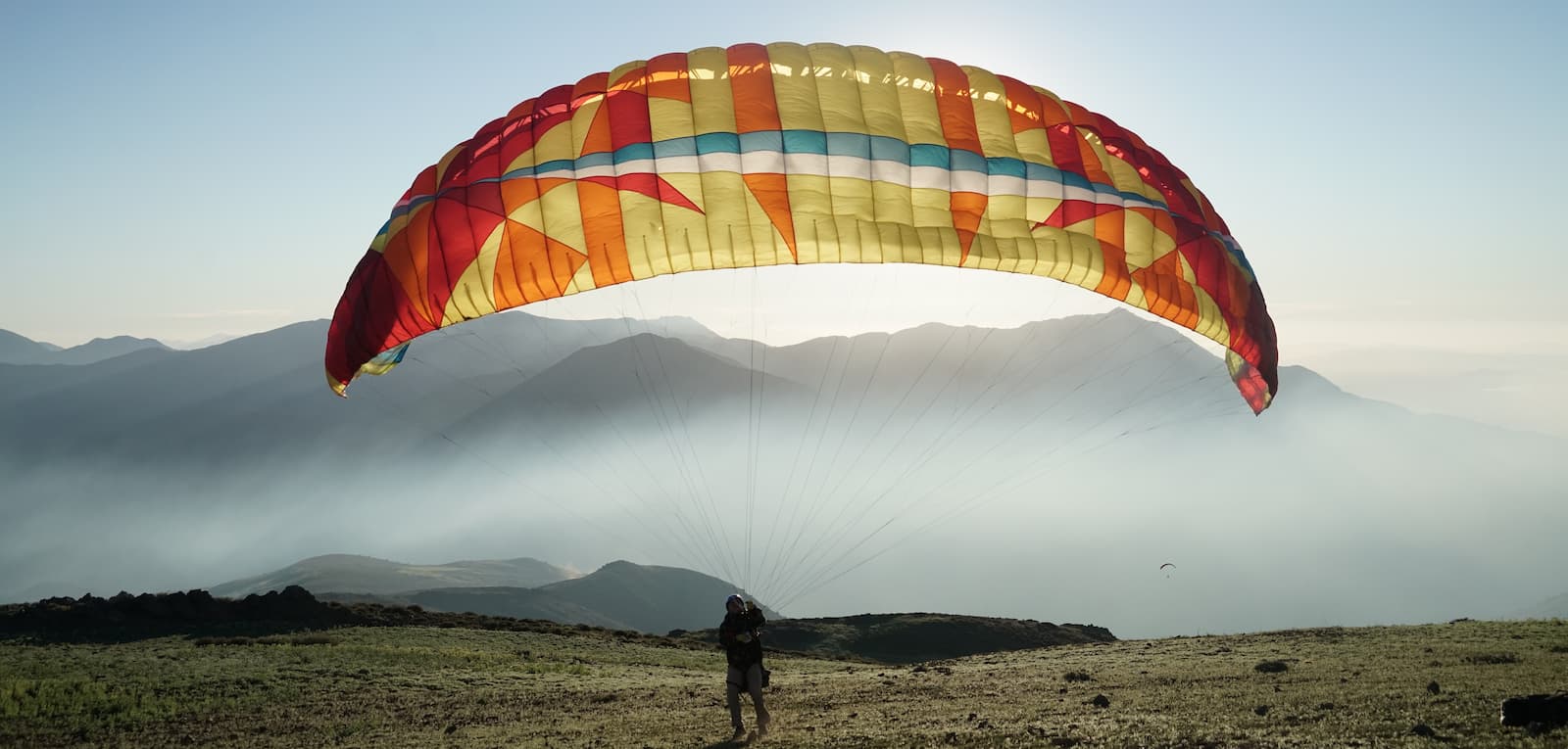 Person launching paraglider on edge of mountin near Pucón, Chile